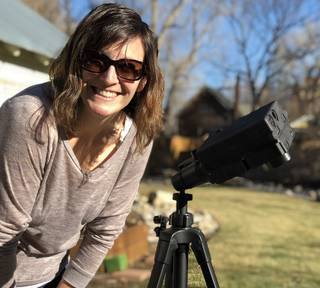 A citizen scientist sets up an air quality sampler in her backyard