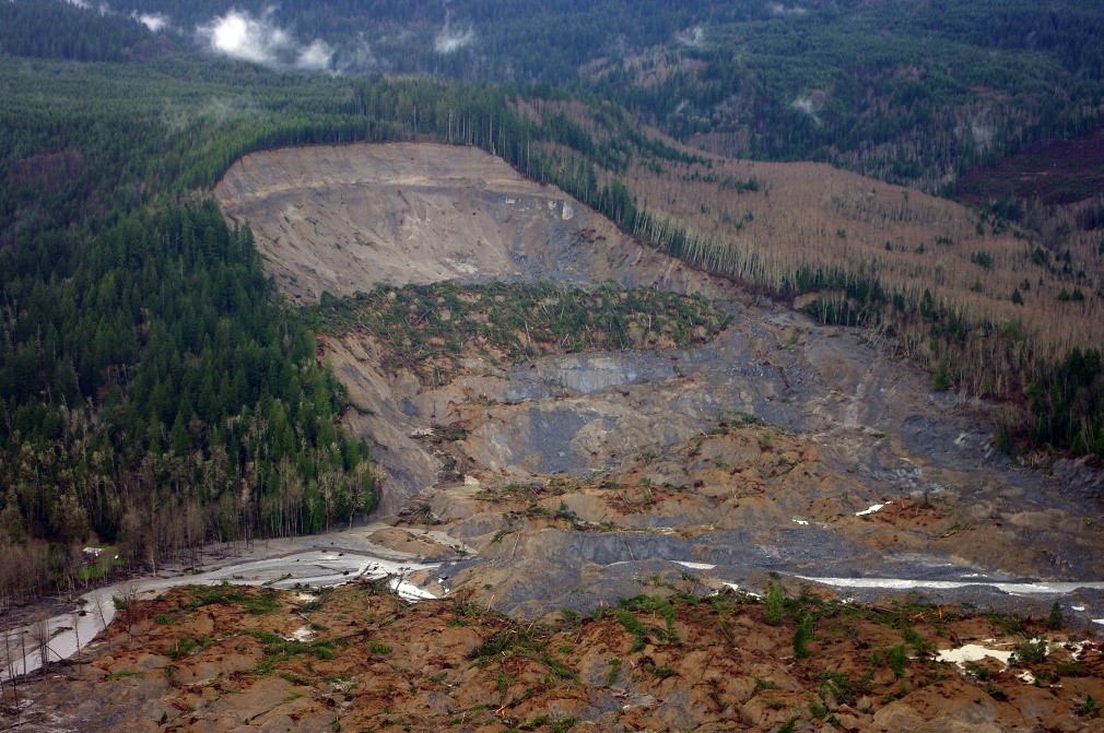 This photograph from an aerial survey shows the upper parts of the 2014 Oso landslide in northwest Washington. NASA’s landslide inventory documents events such as this one to improve model validation. Credit: USGS/Jonathan Godt
