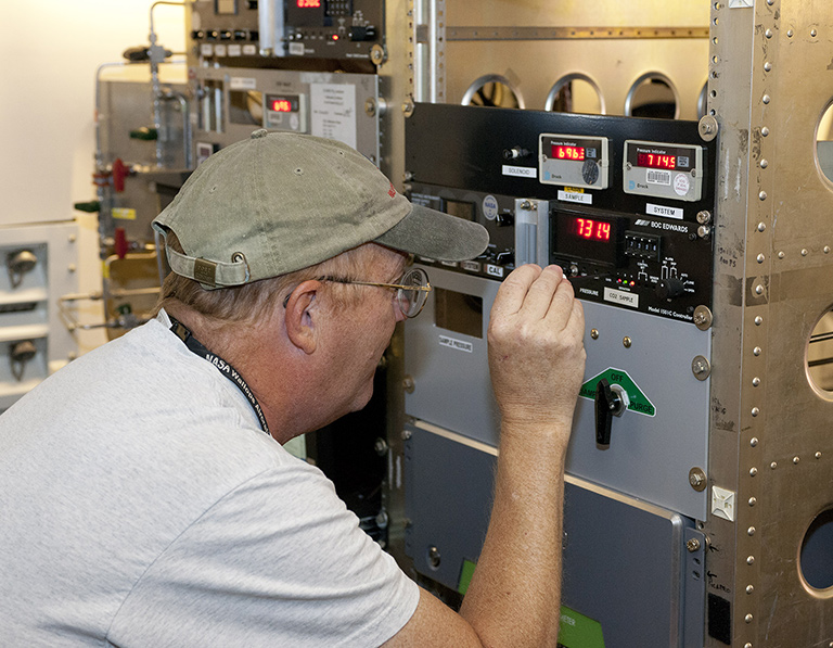 Jim Plant of NASA's Langley Research Center works on in situ instrumentation on board the DC-8. In situ, Latin for "in position," is a term used to describe instruments that make measurement in a specific place. Analysts use in situ readings to judge the accuracy of experimental instruments. Credit: NASA/Tom Tschida